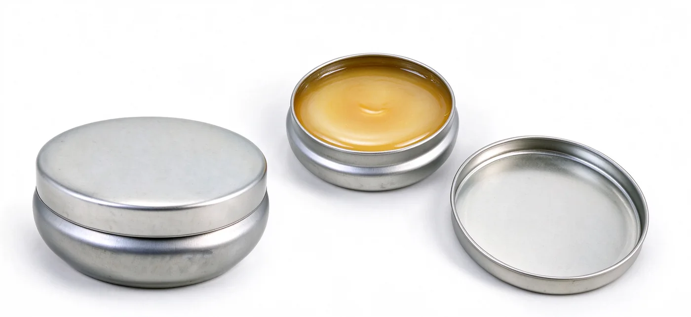 Round silver balm tin shown closed and open